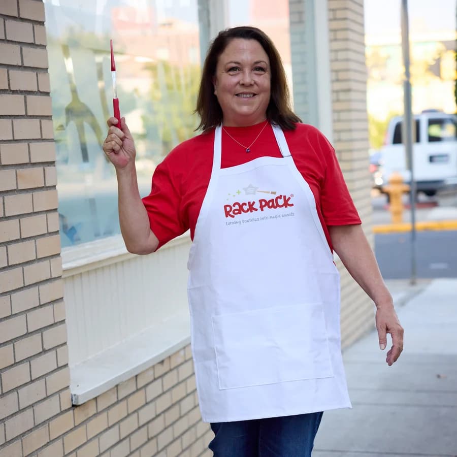 Liz Kupillas, Rack Pack's founder, holding a paintbrush